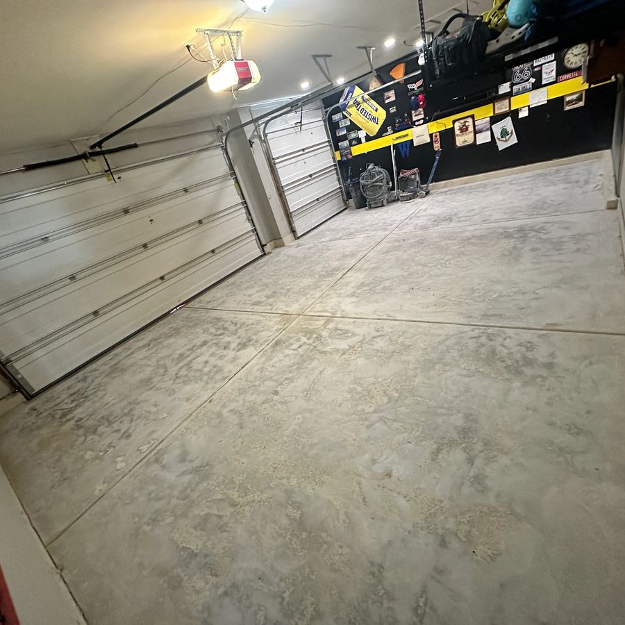 Before epoxy: worn, stained concrete garage floor with control joints