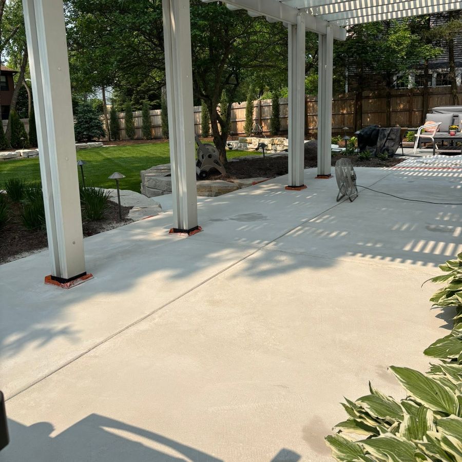 After: resurfaced and coated concrete patio under a pergola by Naperville Painting & Epoxy Flooring
