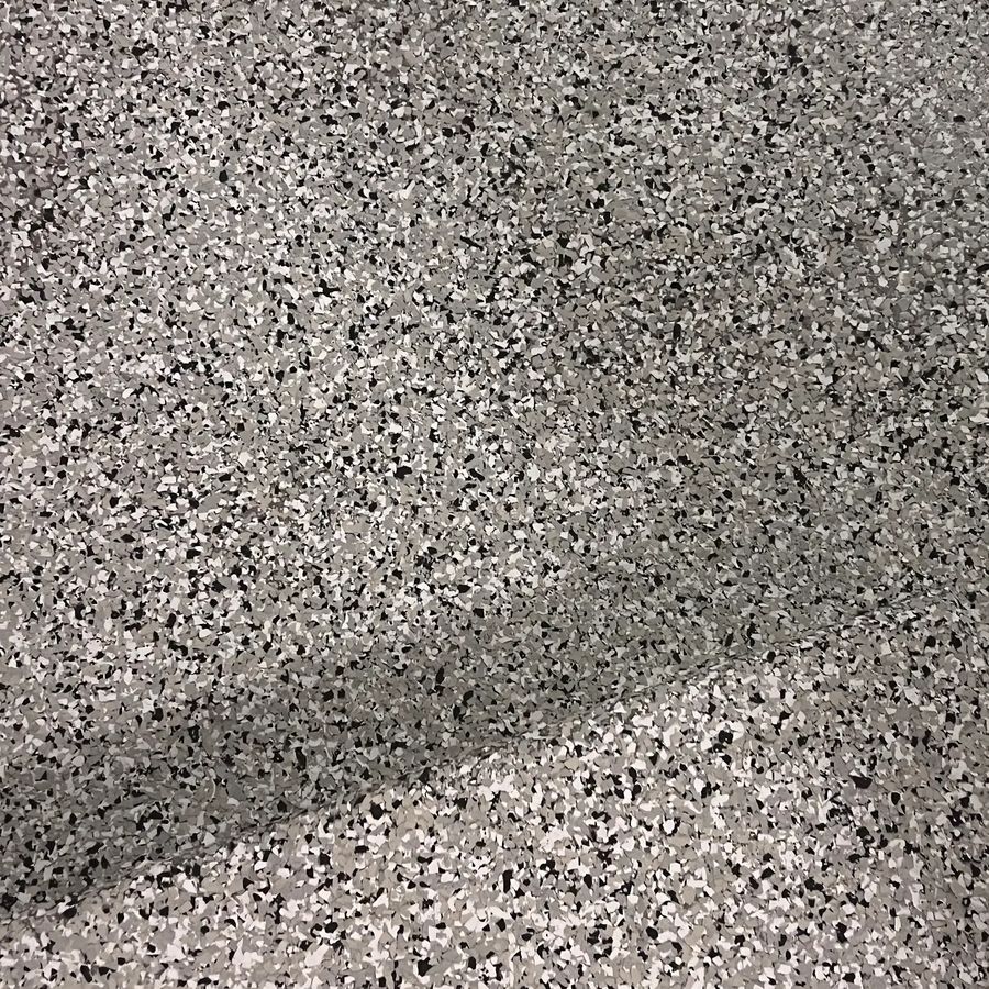 Close-up of gray, black and white decorative flake in an epoxy garage floor coating