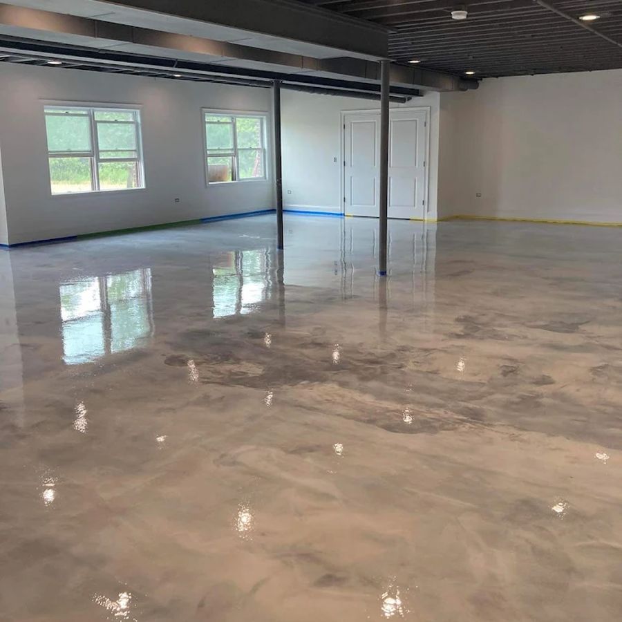 Gray metallic epoxy basement floor with a mirror-like finish in an open basement